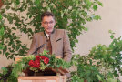 Ein Mann an einem mit Blumen geschmückten Rednerpult