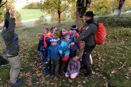 Viele Kinder in Winterkleidung stehen im Wald, halten sich an den Händen